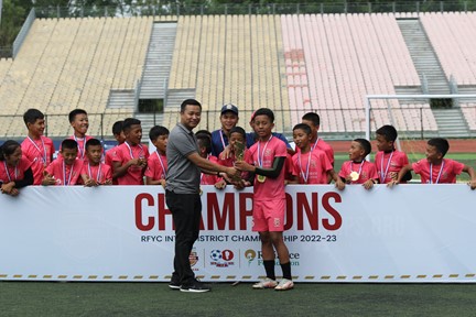 Tetea Hamar hands over the winners' trophy to the U-13 champions